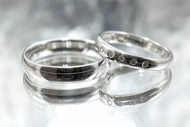 Wedding rings Wedding rings made of white gold with diamonds on a grey background funkeln stock pictures, royalty-free photos & images