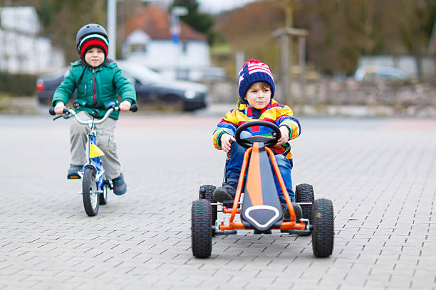 istock Two little boys playing with race car and bicycle 519470544