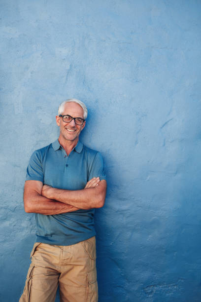 istock Smiling mature man standing with his arms crossed 519471012