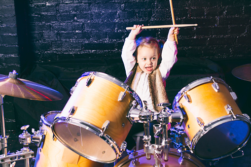 Young female dummer playing in the popular music concert.