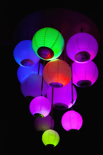 Group of colored paper lanterns glowing in the dark