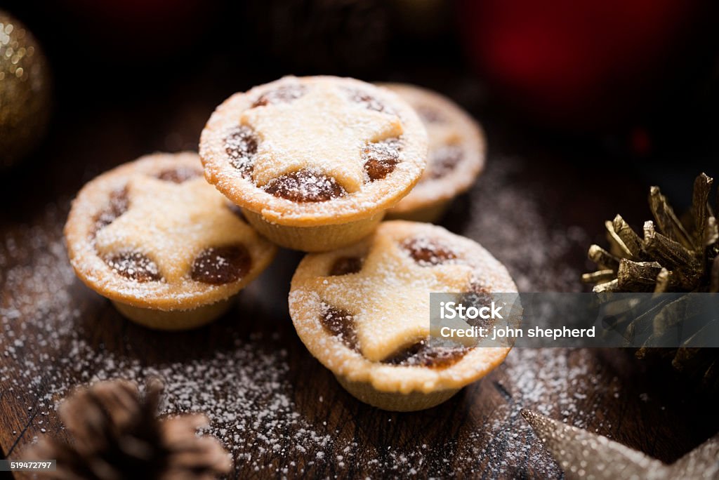 Mince Pies Three small Mince Pies, dusted with icing sugar with Christmas decorations. Mince Pie Stock Photo