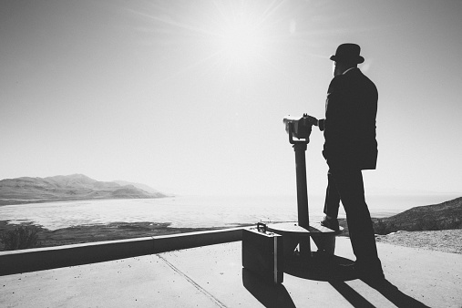 Businessman standing by viewpoint telescope, Business vision concept.