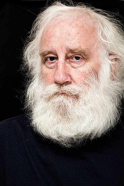istock intense senior white bearded man on dark background 519472945