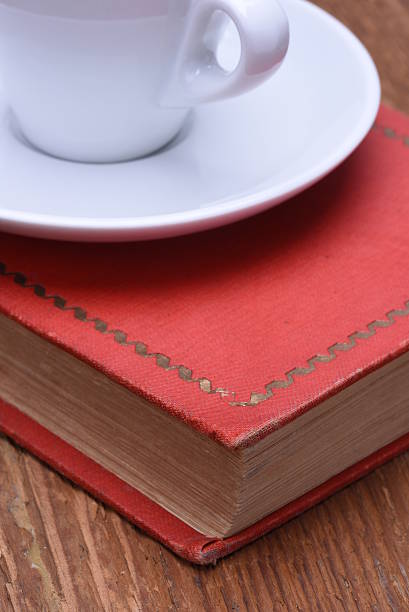 istock Cup of coffee and book on wooden table 519473980