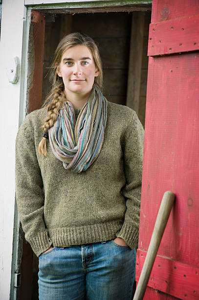 jeune agriculteur femme dans une grange. - mahone bay photos et images de collection