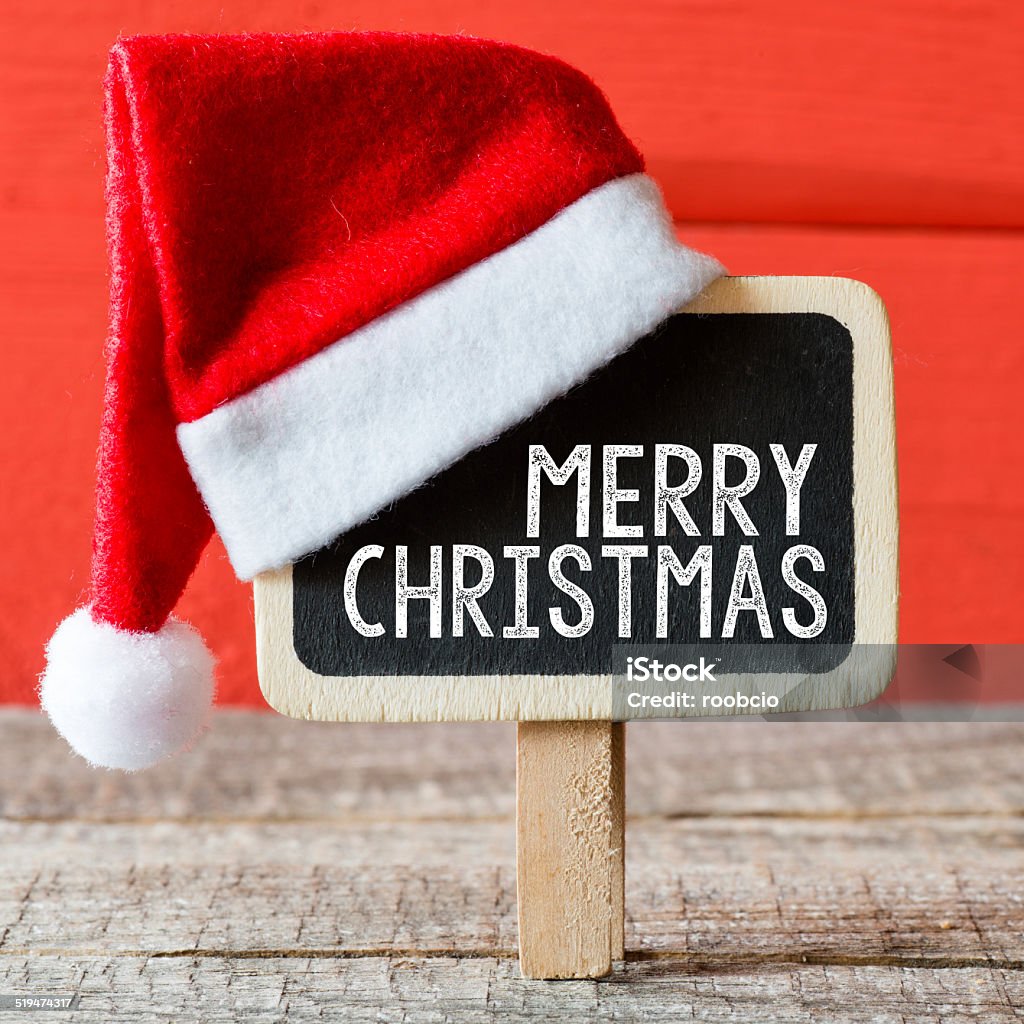 Christmas decorations Merry Christmas. Christmas decorations with Christmas hat with place for greeting on chalk blackboard. Candle Stock Photo