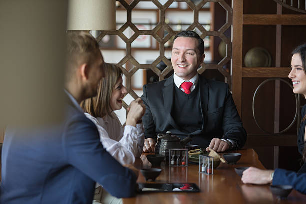 heureux hommes d'affaires dans le restaurant - restaurant business person setting the table clothing photos et images de collection