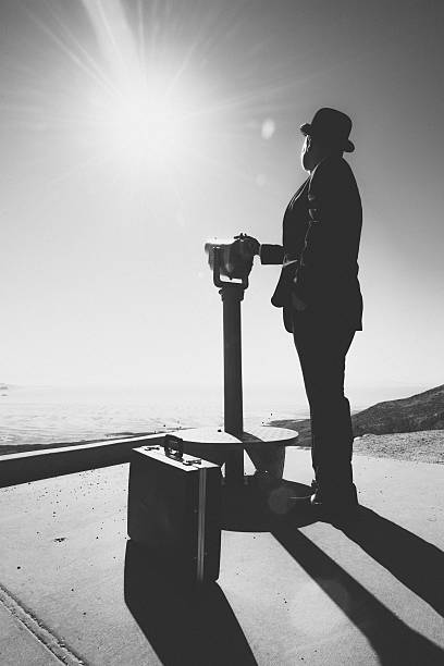 istock Businessman standing by viewpoint telescope 519474597