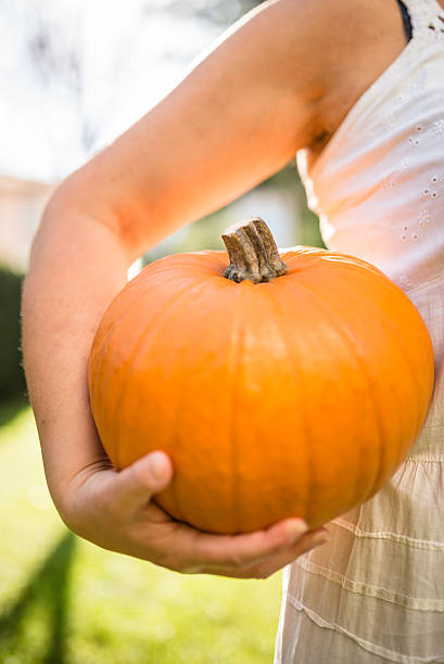 istock woman holding an halloween pumpkin 519474617