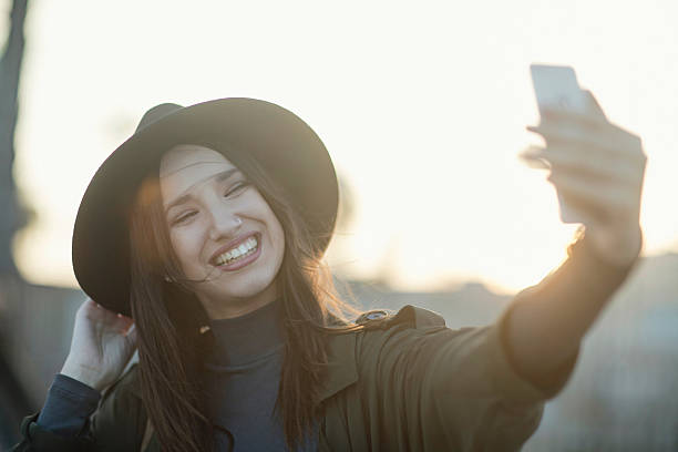 istock Beautiful young woman taking a selfie at sunset 519474712