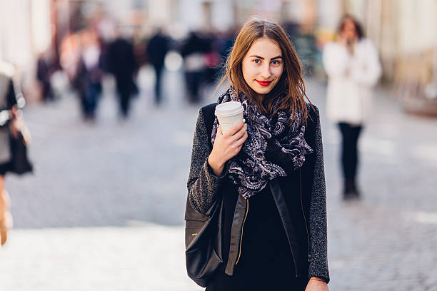 istock Young girl walking on the street with cup 519475314