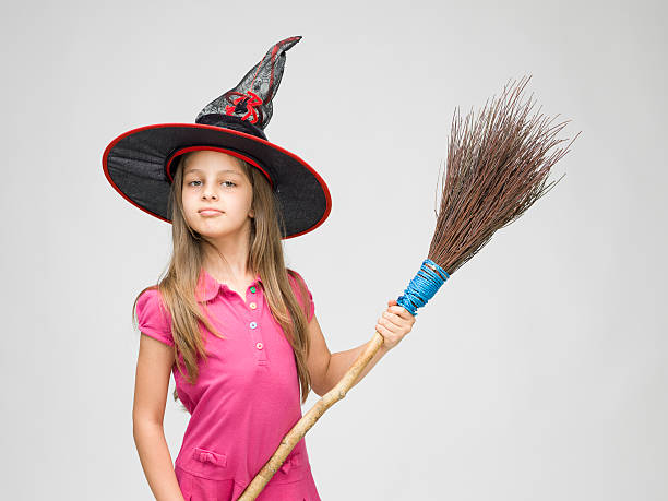 istock Little girl with witch's hat and real broom 519475437