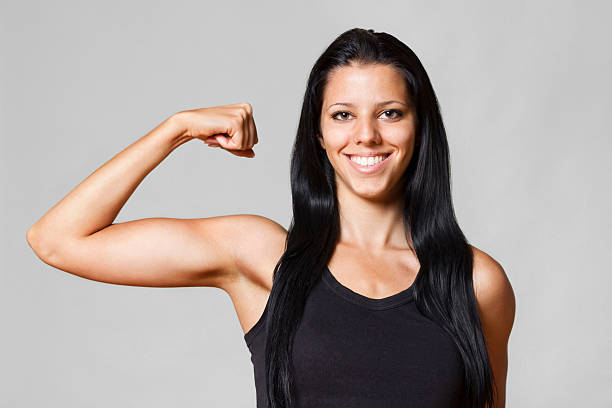 chica mostrando de biceps - human muscle women bicep girl power fotografías e imágenes de stock