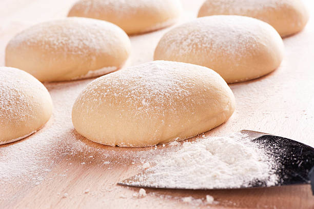 istock Fresh homemade pizza dough on floured wooden 519489499