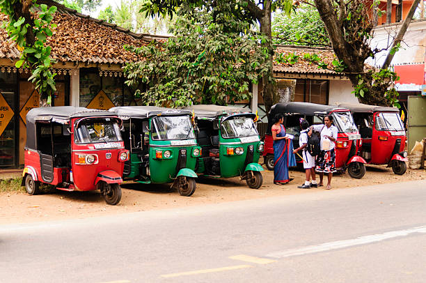Series tuk-tuk taxi Pinavella, Sri Lanka - February 5, 2016: Row of red, blue and green empty tuk-tuks waits for passengers. Tuk-tuk is a popular asian transport as taxi. taxi sri lanka stock pictures, royalty-free photos & images