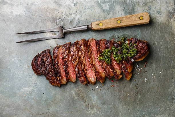 istock Sliced steak with chimichurri sauce and meat fork 519492362
