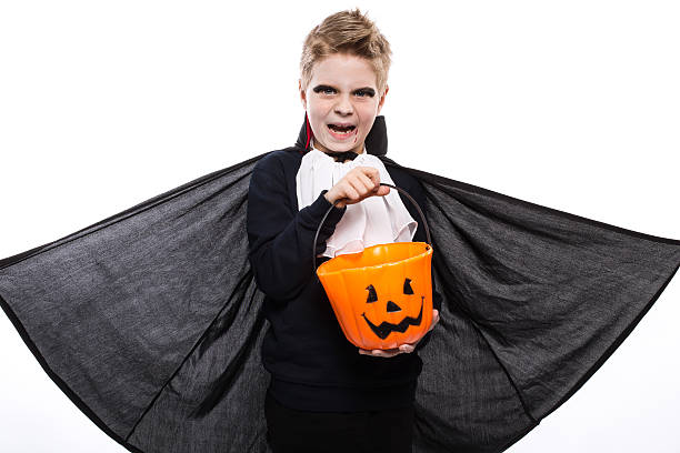 istock Boy with pumpkin basket dressed like vampire for Halloween party 519492705