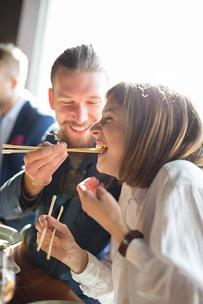 fütterung mit suchi - eating men food chopsticks stock-fotos und bilder