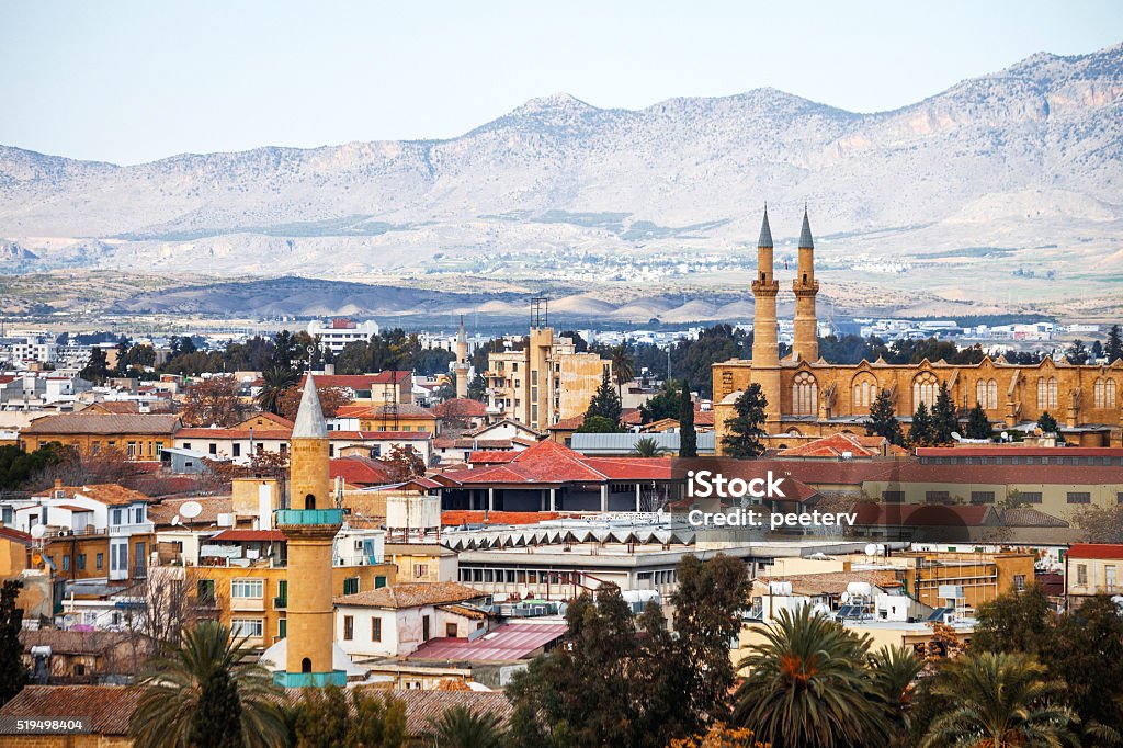 View to Nicosia, Cyprus. View to Nicosia over palm trees, mosque in Turkish side. Nicosia - Cyprus Stock Photo
