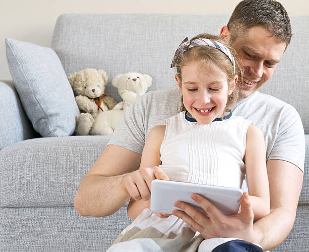 istock Little girl and her father having fun with tablet pc. 519499750