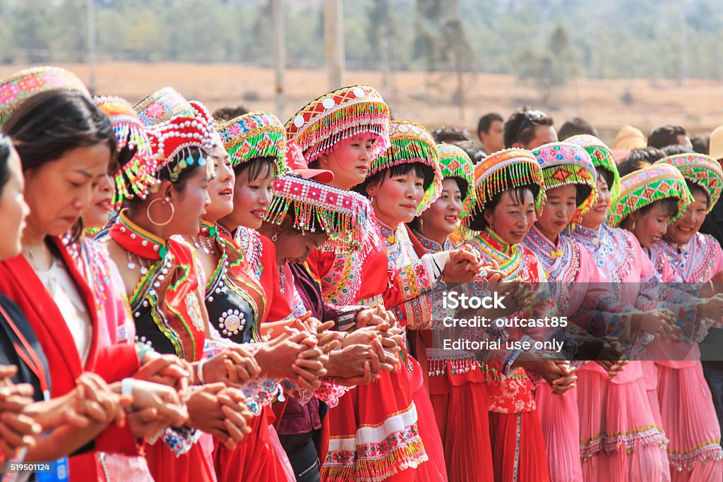 Chinese women dressed with traditional clothing dancing and singing Heqing, China - March 15, 2016: Chinese women dressed with traditional clothing dancing and singing during the Heqing Qifeng Pear Flower festival Miao Minority Stock Photo