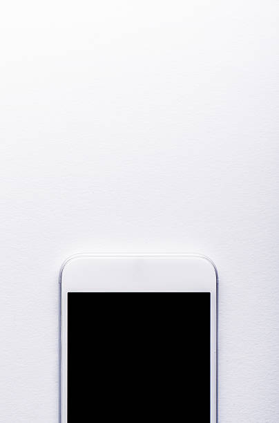 istock Smart phone laid on white office desk, copy space 519502362