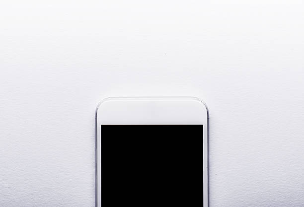 istock Smart phone laid on white office desk, copy space 519502472