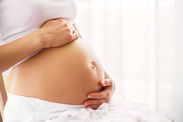 mulher grávida segurando a barriga - abdomen women loving human hand imagens e fotografias de stock