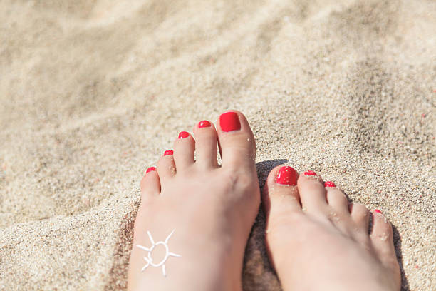 donna in piedi su una spiaggia di sabbia d'estate, primo piano - human foot barefoot sole of foot human toe foto e immagini stock