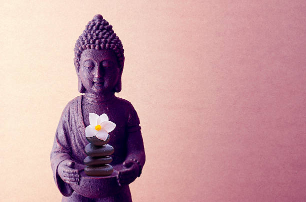 istock Buddha statue on a beige background with flower 519505438