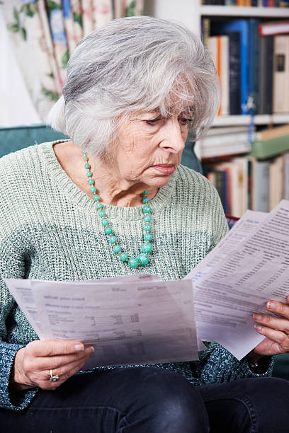 istock Senior Woman Going Through Bills And Looking Worried 519508425