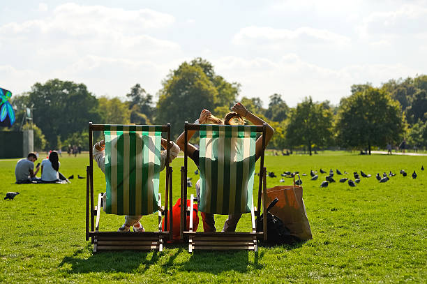 en una silla reclinable mientras se relaja en hyde park - hyde park fotografías e imágenes de stock