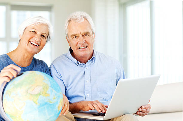 istock Couple With Laptop And Globe Planning Vacation At Home 519510277