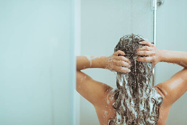 lavado de cabeza de mujer joven con shampoo. vista posterior - long hair rear view brown hair the human body fotografías e imágenes de stock