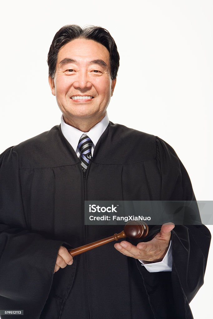 Lawyer holding gavel, smiling, portrait Judge - Law Stock Photo