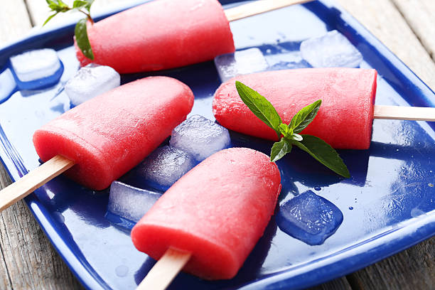 istock Watermelon popsicle on tray on grey wooden table 519518496