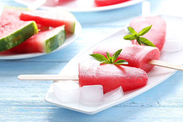 istock Watermelon popsicle on plate on blue wooden table 519518962