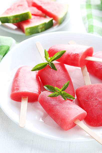 istock Watermelon popsicle on plate on white wooden table 519519482