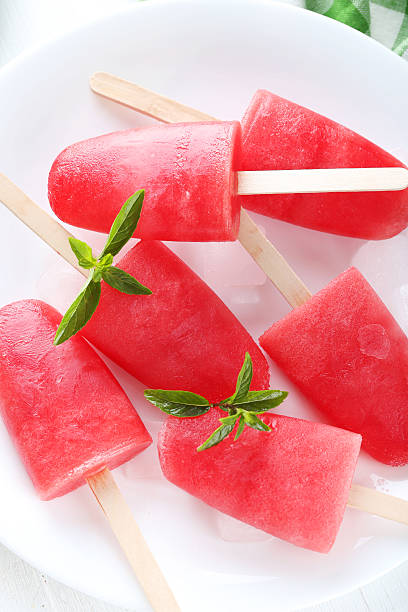 istock Watermelon popsicle on plate on white wooden table 519519556