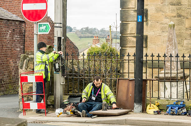Workmen fixing telephone line on a Welsh street. Wrexham, Wales, United Kingdom - March 21, 2016: Openreach workers fixing BT (British Telecom) telephone line outside in the street. british telecom photos stock pictures, royalty-free photos & images