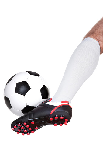 Soccer player kicking the ball isolated on white background