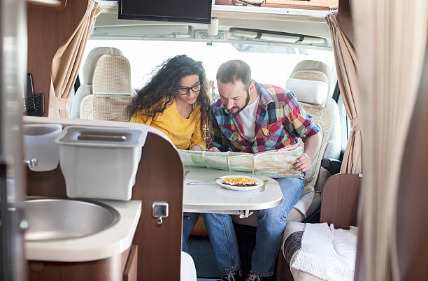 istock Young couple looking at map inside of caravan 519521182
