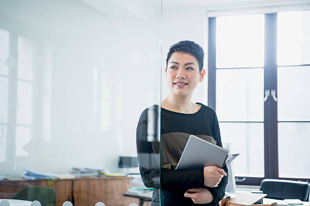 Businesswoman in modern office looking away through partition