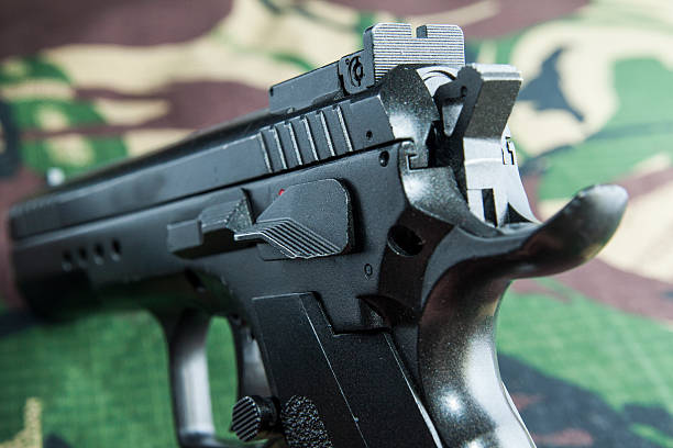 istock Firearm Pistol  on military camouflage background 519522268