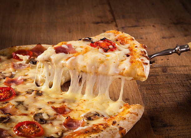 Slice of hot pizza A slice of hot pizza just from the oven with melted cheese dripping pizza stock pictures, royalty-free photos & images