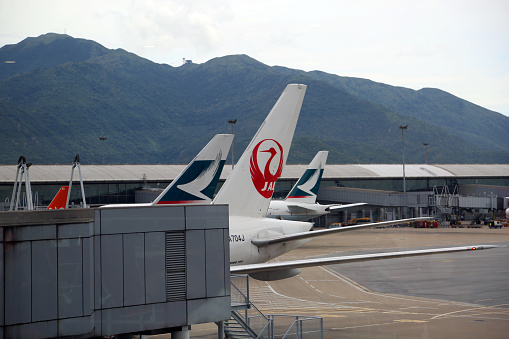 Hong Kong, China - August 7, 2014: A line-up of aircraft tails at Chek Lap Kok Airport (HKG Hong Kong International Airport).  Opened in 1998, the airport is a major hub for travel in Asia.
