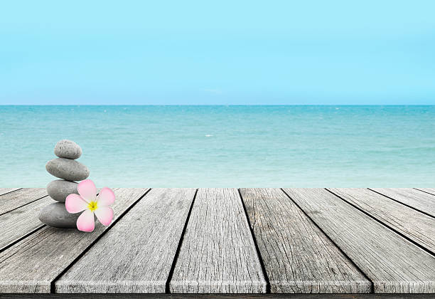 Stack of pebble stones at the beach on a wooden
