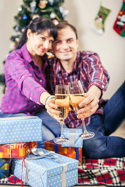 istock Young couple with goblets of champagne wine under christmas tree 519534643