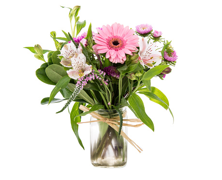 Beautiful Bouquet of pink Gerbera Daisies and purple and white wild flowers in clear glass vase Isolated on white background